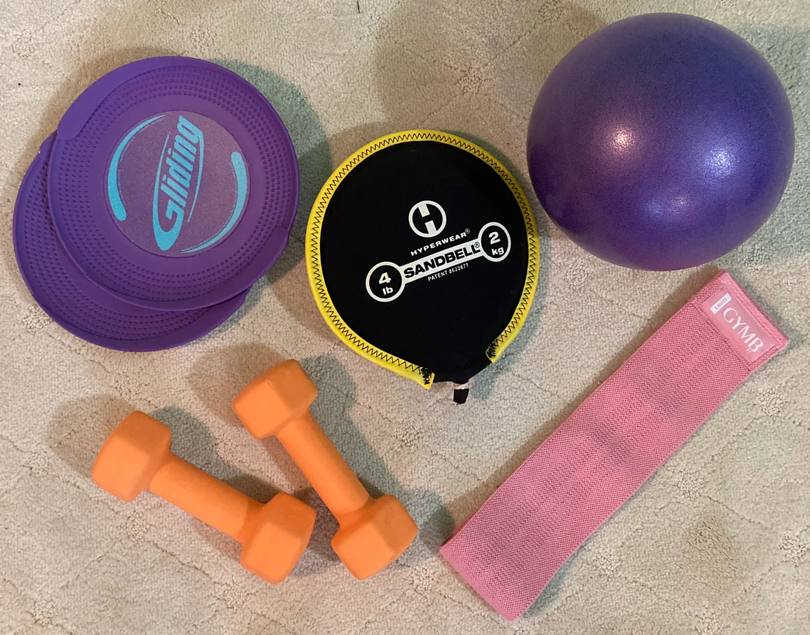 Recommended at-home equipment for senior fitness classes: dumbbells, resistance band, exercise ball, and gliding discs — all optional